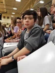 Eighth grader sitting in the stands of Froshfest