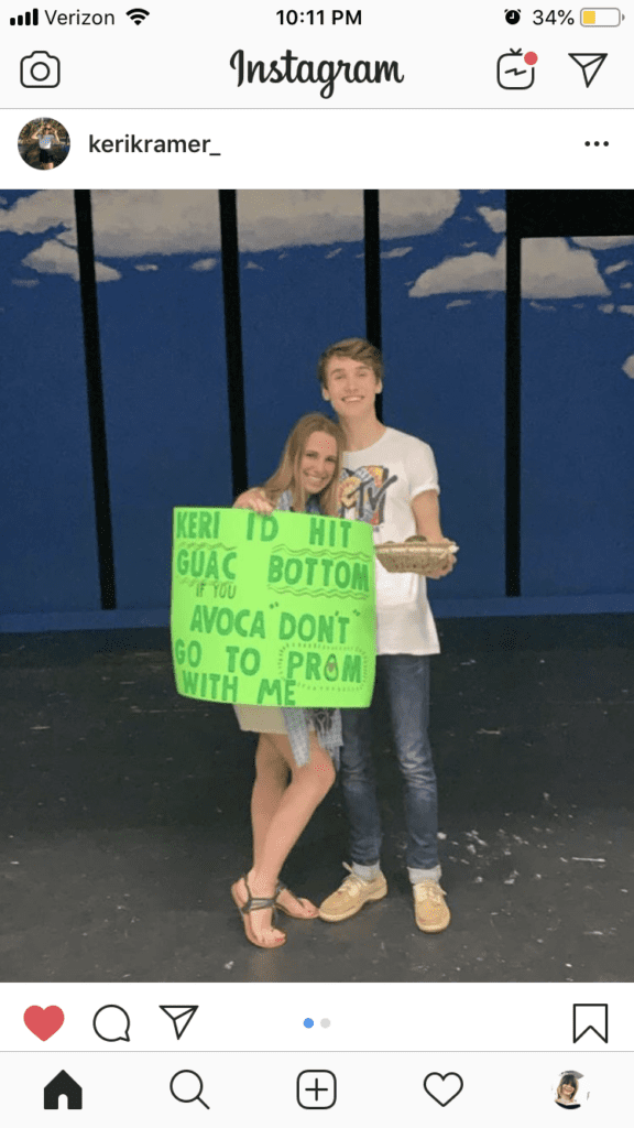 A couple with a sign saying "Keri I'd hit GUAC bottom if you AVACA-DON'T go to prom with me